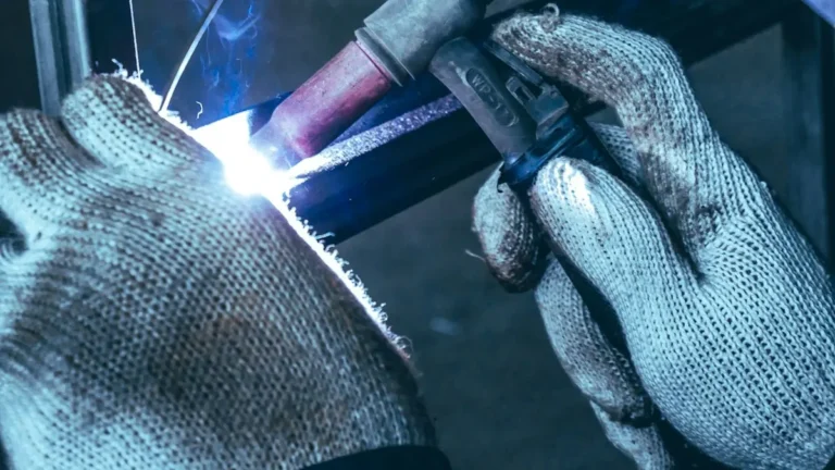 Soldador trabajando en una pieza de metal en un taller